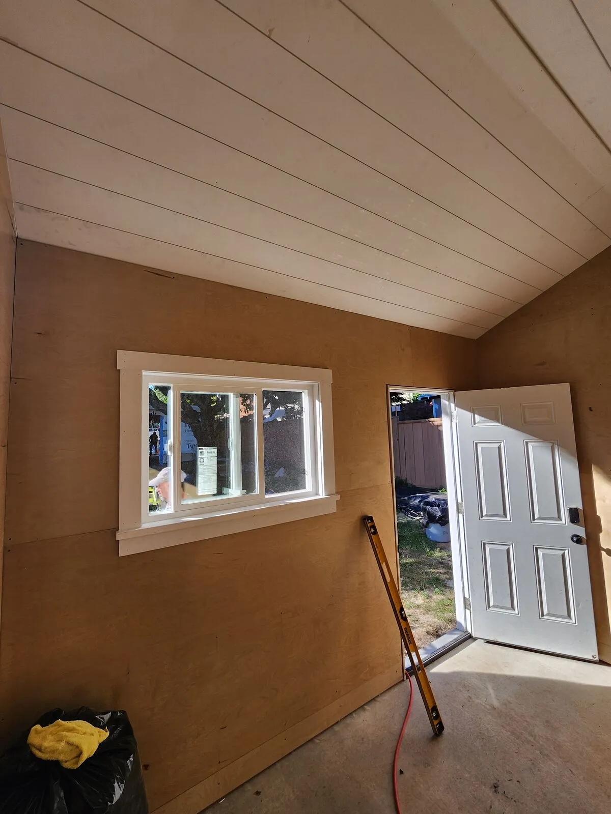 Finished interior: plywood walls and a painted shiplap vaulted ceiling
