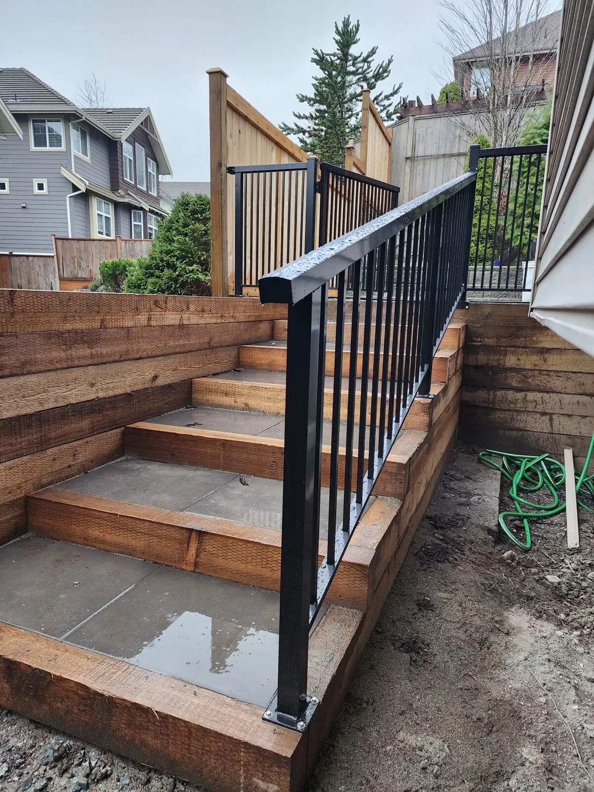 Concrete-and-timber stairs with black aluminum railing