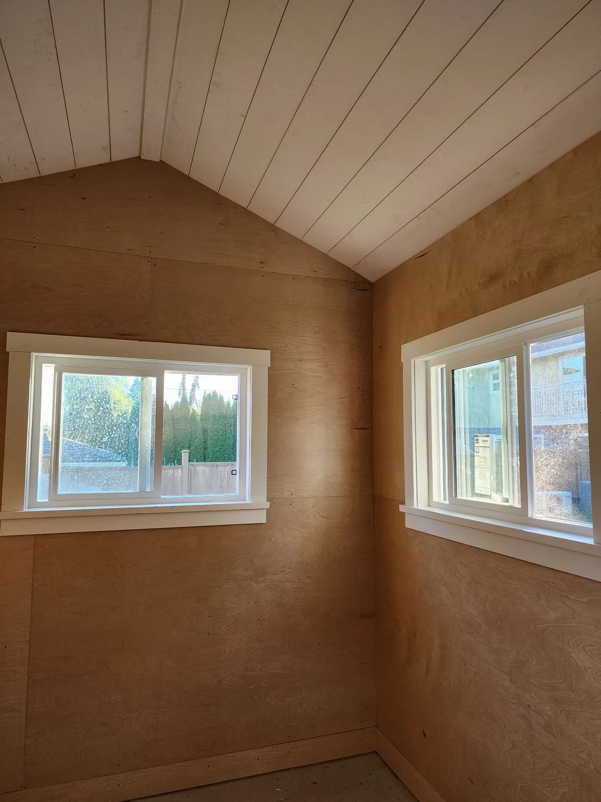 Finished interior: plywood walls and a painted shiplap vaulted ceiling