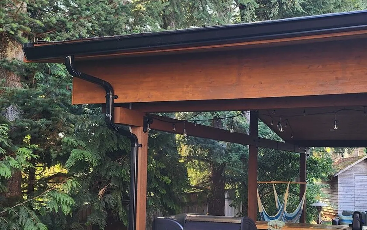 Cedar post-and-beam patio cover with hanging lights in Langley, BC